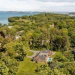 Aerial 3D rendering (photomontage) of a large property with a house and pool, surrounded by dense green trees near the ocean.