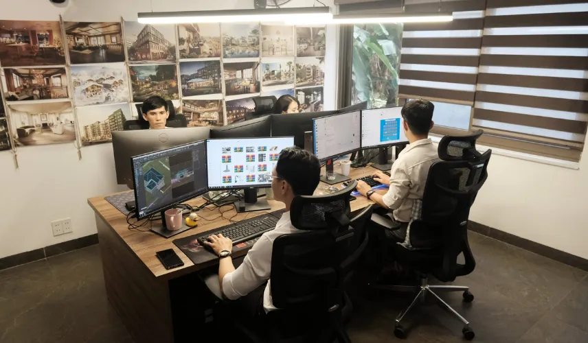 3D architectural rendering studio workspace with designers working on architectural visualization projects